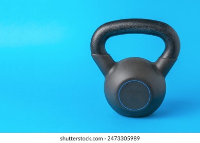 Black Kettlebell on Blue Background for Fitness and Strength Training