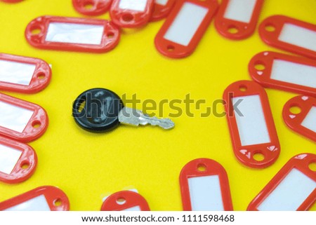 The black key is among empty unsigned tags on a yellow background