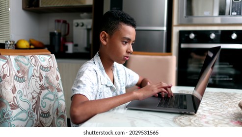 Black Kid In Front Of Laptop At Home. Child Browsing Internet Online Computer