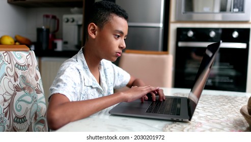 Black Kid In Front Of Laptop At Home. Child Browsing Internet Online Computer