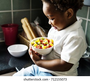 Black Kid With Fruit Salad In The Kitchen