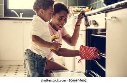 Black Kid Helping Mom Baking Cookies In The Kitchen