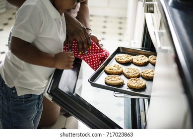 Black Kid Helping Mom Baking Cookies In The Kitchen