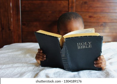 Black Kid Reading The Holy Bible.