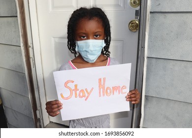 Black Kid Wearing Surgical Mask Holding Stay Home Sign Outside House