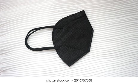 A Black KN95 Mask On Pleated Fabric Texture