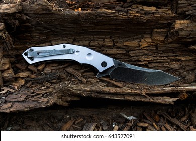 Black knife with gray handle. Brown wood.