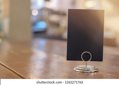 Black Label In Cafe. Display Stand For Acrylic Tent Card In Coffee Shop. Mockup Menu Frame On Table In Bar Restaurant. Space For Text