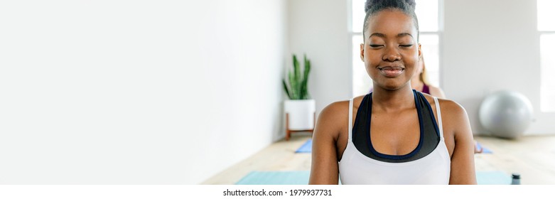Black lady doing a Sukhasana yoga pose