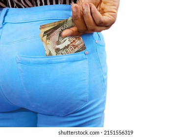 Black lady putting few Kenyan shilling notes into her back pocket. Removing money from pocket, hold money