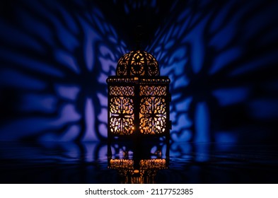 Black lantern with reflection from blue background for the Muslim feast of the holy month of Ramadan Kareem.
