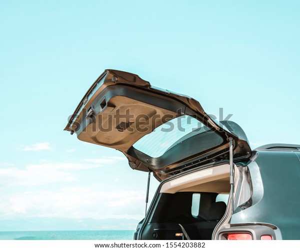Black large car with an open\
luggage carrier parked on the beach. Sea landscape and free space\
for your product or text. Summer and sunny warm day. Copy\
space.