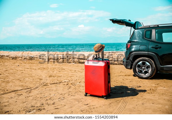 Black large car with an open\
luggage carrier parked on the beach. Sea landscape and free space\
for your product or text. Summer and sunny warm day. Copy\
space.
