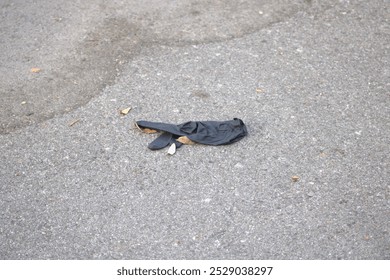 black latex glove on pavement ground - Powered by Shutterstock