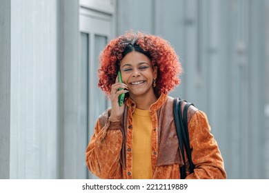 Black Latin American Woman Walking Down The Street Talking On The Phone