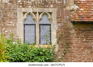 Black leaded windows in a stone surround in an old medieval cottage