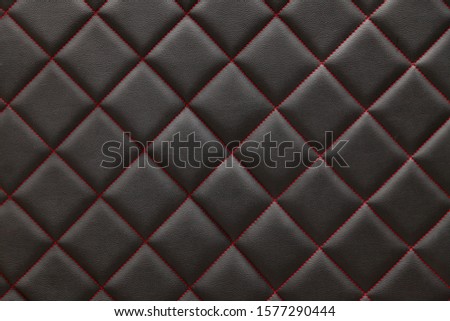 Black  leather background and texture stitched with red diamond-shaped threads as a pattern for the interior of the vehicle's interior waist in the vehicle maintenance workshop.