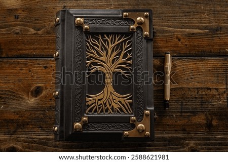 Black leather book with embossed frame, metal corners and, as a symbol, gilded the tree with branches and roots. High resolution.