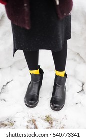 Black Leather Boots With Yellow Sox Legs On The Snow