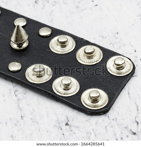 Black leather bracelet adorned with sharp metal spikes, combining bold style with edgy attitude. Perfect for punk, goth, metal, and biker fashion lovers seeking a statement accessory