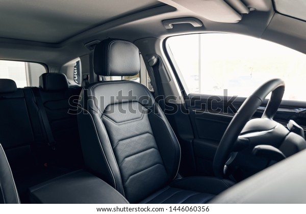 Black leather car interior. Modern car\
interior dashboard and steering wheel. Modern luxury car black\
perforated leather interior. Interior\
details