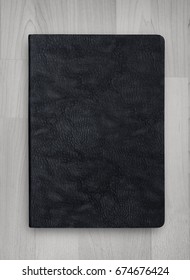 Black Leather Cover Of Notebook On Wood Texture Background 