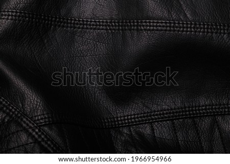 Black leather jacket texture with seams. Background or backdrop, clothing surface.