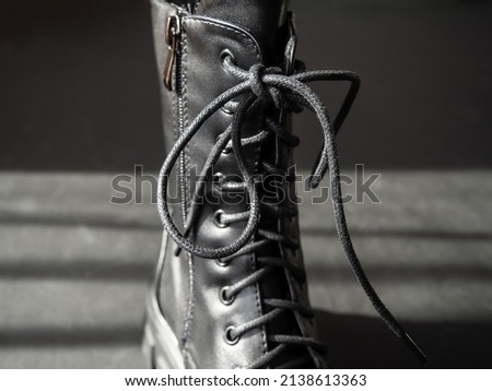 Black leather lace-up boots. Fashionable, stylish collection of women's shoes. Black background.