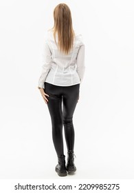 Black Leather Leggings On White Background. Woman In White Shirt And Black Jeggings. Leather Pants. Back View