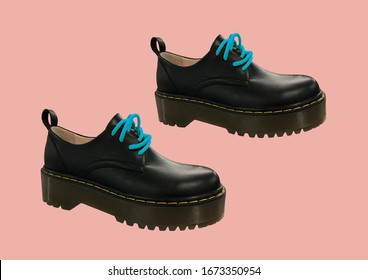 Black Leather Platform Shoes Isolated On Pink Background. Classic Shoes On A High Black Tractor Platform. Fashionable Strict Low-heeled Shoes. Women Loafers With Lacing. Composition Of Clothes