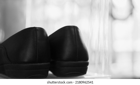 Black Leather Shoes On Natural Light Background. Monochrome Photography