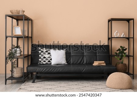 Black leather sofa, cushions and shelving units in living room