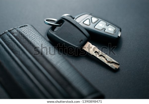 Black\
leather wallet with car key on a black\
background