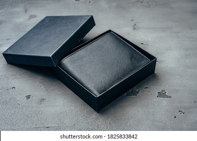 Black leather wallet on grey concrete background