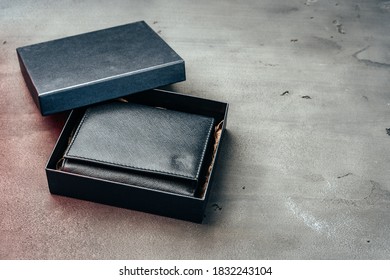 Black leather wallet on grey concrete background