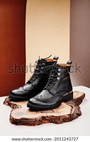 Black leather women's boots made of genuine leather in a classic style on a wooden cut. Close-up. 