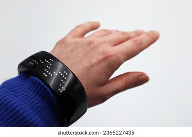 Black led wireless digital loading bracelet vibrant display device monitor on hand wrist in front of white background