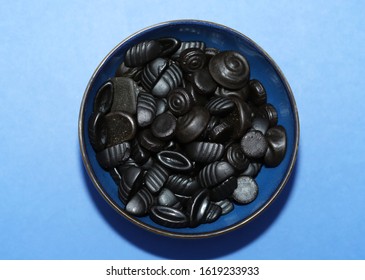 Black Licorice Candy In A Blue Bowl.