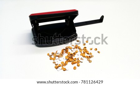 A black lightweight 2-hole filebinder and guide help keep the paper in straight line with small pieces of paper punches isolated on white background. Office supplies tool concept. Copy space with text
