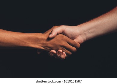 Black lives matter. Human tolerance. Unrecognizable multicolor male hands shaking isolated on dark copy space. Ethnic friendship. No racism. Races agreement