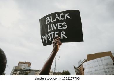  Black lives matter movement protesting in Milan, claiming for antiracism and equal human rights holding "Black lives matter" picket sign - Shutterstock ID 1752257708