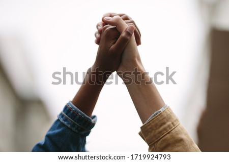 Black lives matter. Symbol of unity. Two women activists holding hands. Demonstrators protesting together holding hands.