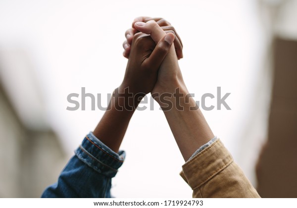 Black\
lives matter. Symbol of unity. Two women activists holding hands.\
Demonstrators protesting together holding\
hands.