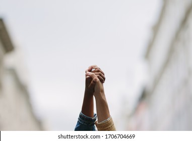 Black lives matter. Symbolic picture showing that we are stronger together. Two people holding hand and raising in unity. Symbol of unity and anti racism. 