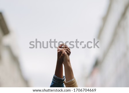 Black lives matter. Symbolic picture showing that we are stronger together. Two people holding hand and raising in unity. Symbol of unity and anti racism. 