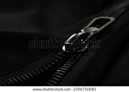 Black lock with a zipper on clothes close-up. Lock.