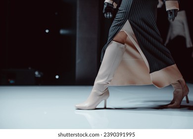 Black long skirt and beige high heels. Fashion model walking runway fashion show - Powered by Shutterstock