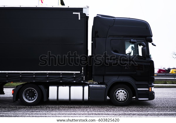 Black lorry trailer with copy space area for\
shipping delivery brand. Truck logistic services. Cargo automobile\
for international transportation. Mock up freight vehicle of\
commercial trade