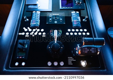 Black luxury yacht control panel with buttons and control levers and on-board computer.