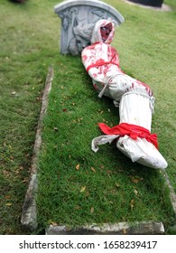 A Black Magic Doll With A Beloved Dog Lying On The Grave.